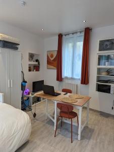 a bedroom with a desk with a laptop and a bed at Studio Vue Loir, Centre-Ville in Bonneval