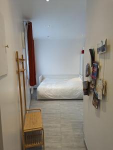 a room with a bed and a refrigerator and a chair at Studio Vue Loir, Centre-Ville in Bonneval
