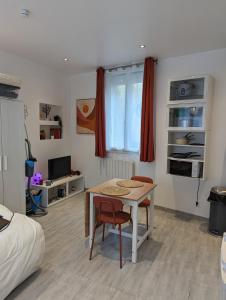 a room with a table and two chairs and a bed at Studio Vue Loir, Centre-Ville in Bonneval