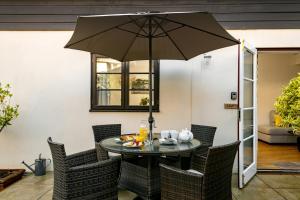 a table with an umbrella in a patio at Bulverton House Holiday Cottages in Sidmouth