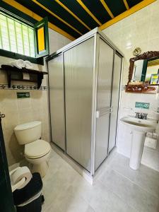 a bathroom with a shower and a toilet and a sink at Finca Hotel el Palmar in Montenegro