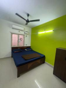 HOME STAY in ground floor في تشيناي: غرفة بسرير وجدار أخضر