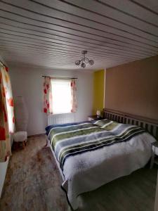 ein Schlafzimmer mit einem großen Bett in einem Zimmer mit einem Fenster in der Unterkunft Waldhaus Klein-Veitsch, Auszeit im Grünen in Niederaigen