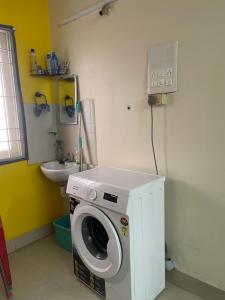 HOME STAY in ground floor في تشيناي: وجود غسالة في الحمام مع وجود مغسلة