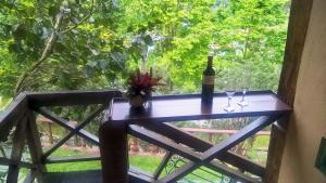 a table with a bottle of wine and two glasses at Pousada Monte Imperial in Petrópolis