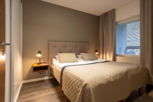 Un dormitorio con una cama grande y una ventana en Vuokatti Booking Suites en Vuokatti