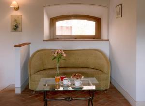 a couch with a vase of flowers on a table at Borgo Sant'Ambrogio - Resort in Pienza