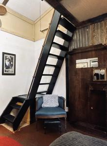 una escalera con una silla azul en una habitación en Acorn Hideaways Canton Gold Panner Bunkhouse King Bed, en Canton