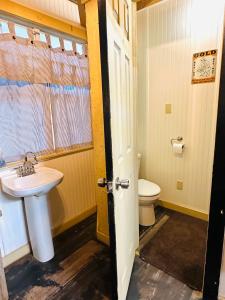 a bathroom with a sink and a toilet at Acorn Hideaways Canton Gold Panner Bunkhouse King Bed in Canton