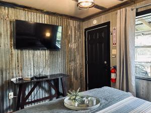 a bedroom with a bed and a television on a wall at Acorn Hideaways Canton Gold Panner Bunkhouse King Bed in Canton