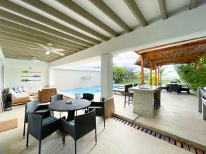 sala de estar con mesa y sillas y piscina en Casa de Playa, en Cartagena de Indias