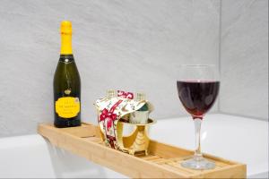 a bottle of wine and a glass of red wine at Central Buckingham Apartment #9 with Free Parking, Pool Table, Fast Wifi and Smart TV with Netflix by Yoko Property in Buckingham