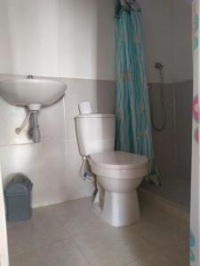 a bathroom with a toilet and a sink at Hostal El Nido del Azulejo in Barú