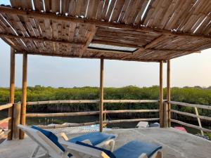un patio con sillas, una piscina y un techo de madera en Hostal El Nido del Azulejo, en Barú