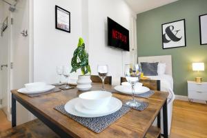 Central Buckingham Apartment #9 with Free Parking, Pool Table, Fast Wifi and Smart TV with Netflix by Yoko Property في باكنغهام: غرفة طعام مع طاولة مع الأطباق وكؤوس النبيذ