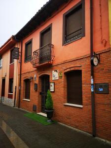 a red brick building with a clock on it at Casa Rural Las Singer in Mansilla de las Mulas