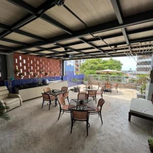 un patio con mesas y sillas y una cocina. en STUDIO 202 | WIFI 600MB | RESIDENCIAL JC, um lugar para ficar., en Belém