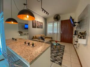 uma cozinha e uma sala de estar com uma bancada em Apartamento de frente com sacada no centro de Capão da Canoa em Capão da Canoa