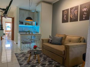 a living room with a couch and a table at Apartamento de frente com sacada no centro de Capão da Canoa in Capão da Canoa