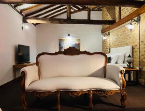 a white couch in a room with a bed at Hotel Caney Villa de Leyva by MH in Villa de Leyva