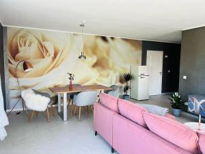 a living room with a pink couch and a table at Apartment Am Paradies in Bad Lauterberg