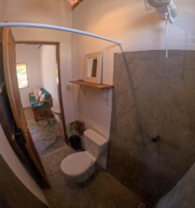 a bathroom with a toilet and a shower at Pousada Vila Jasmim em Caraíva in Caraíva