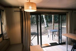 um quarto com portas de vidro deslizantes que levam a um pátio em Lodge avec SPA privatif - Foret et Lac em Liginiac