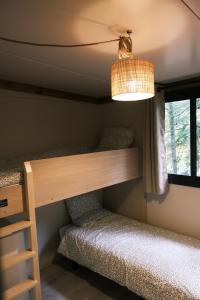 um beliche num quarto com uma janela em Lodge avec SPA privatif - Foret et Lac em Liginiac