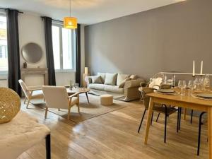 ein Wohnzimmer mit einem Tisch und einem Sofa in der Unterkunft Pure - Hypercentre 4 personnes à 2 rues de l'Avenue de Champagne - Balnéo in Épernay