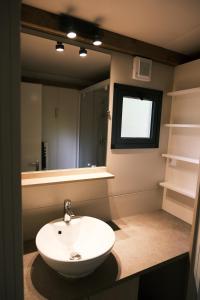 uma casa de banho com um lavatório branco e um espelho. em Lodge avec SPA privatif - Foret et Lac em Liginiac