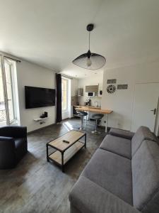 a living room with a couch and a table at Studio de l'hôtel de ville in Charleville-Mézières