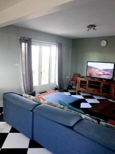 sala de estar con sofá azul y TV en Lux - Palace Apartment Trou Aux Biches en Trou aux Biches