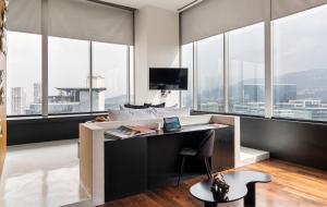 een slaapkamer met een bureau en een laptop. bij Collection Suites by Kukun in Mexico-Stad