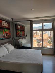 1 dormitorio con cama y ventana grande en San Peter Apartments, en Medellín