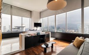 een woonkamer met een bank en een bureau bij Collection Suites by Kukun in Mexico-Stad