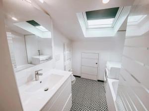 a white bathroom with a sink and a mirror at Libourne - CARNOT - Centre Ville in Libourne