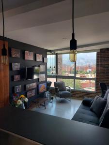 sala de estar con sofá y TV en San Peter Apartments, en Medellín