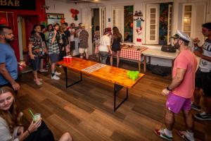 eine Gruppe von Menschen, die um einen Tisch in einem Zimmer stehen in der Unterkunft Books Hostel in Rio de Janeiro