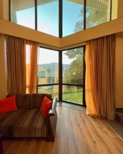 a living room with a couch and a large window at Dilijan Park Resort & Villas in Dilijan