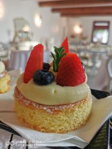 a cupcake with fruit on top of it on a plate at B&B Riva del Gallo in Tresigallo