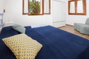 1 dormitorio con 1 cama azul y 2 almohadas en Casa al Mare, en Capoliveri