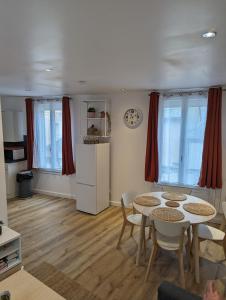 a living room with two tables and a refrigerator at Duplex de 65 m2, Cœur de Bonneval in Bonneval