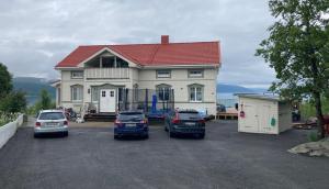 uma casa com três carros estacionados num parque de estacionamento em Brand New Studio Apartment in Tromso - hotspot em Tromsø