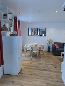 a kitchen and living room with a table and a refrigerator at Duplex de 65 m2, Cœur de Bonneval in Bonneval