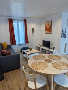 a living room with two tables and a couch at Duplex de 65 m2, Cœur de Bonneval in Bonneval