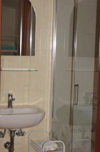 een badkamer met een wastafel en een douche bij Geoglobe Chambre d'Hòtes in Pisa