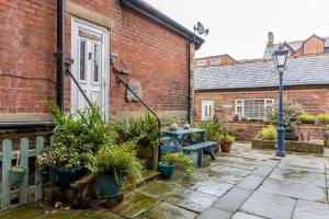 um pátio com uma mesa azul e algumas plantas em Beach Snug em Lytham St Annes