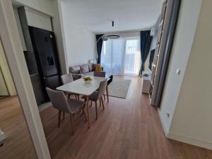 een eetkamer en een woonkamer met een tafel en stoelen bij Aqua Royal BW apartment in Sajmište