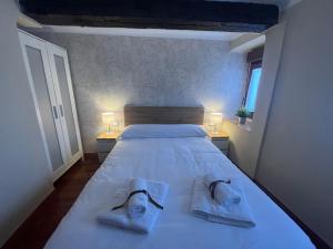 1 dormitorio con 1 cama con toallas y 2 lámparas en La Escapada 