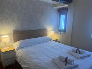 ein Schlafzimmer mit einem weißen Bett mit zwei Handtüchern darauf in der Unterkunft La Escapada 